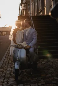 Gegenlicht - Sonne Braut & Bräutigam küssen sich an der Vespa