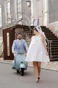 Braut läuft vor der Vespa des Bräutigam