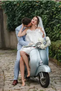 Braut Bräutigam eng umschlungen auf der Vespa